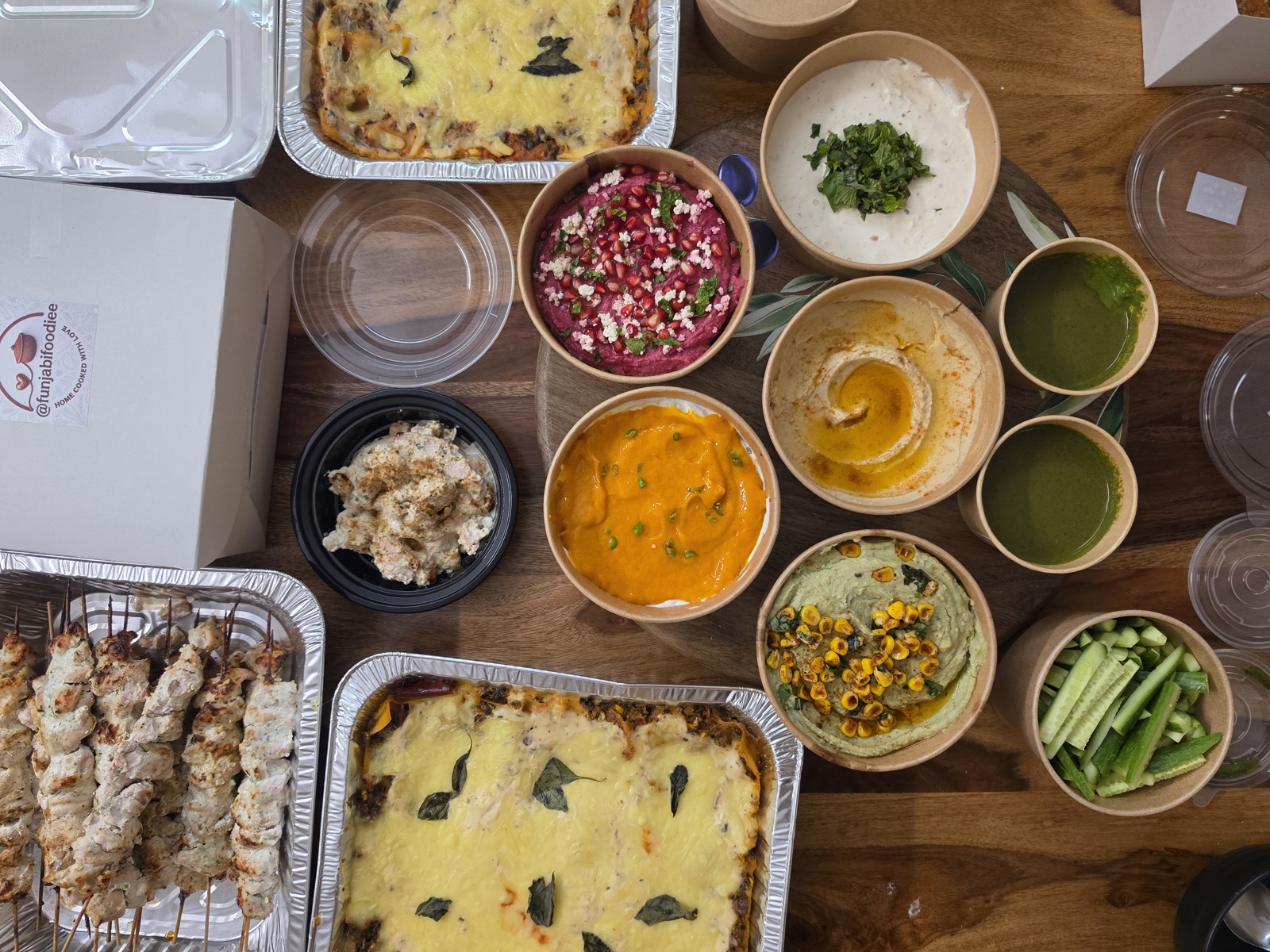 A full Funjabi Foodiee catering spread — kebabs, dips, hummus and bakes